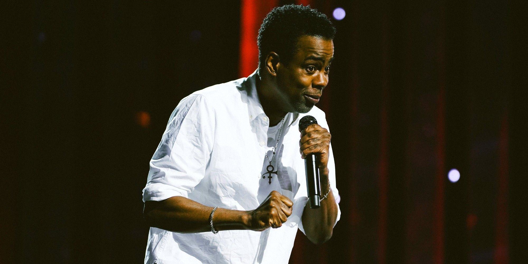 Chris Rock standing on stage and holding microphone during Netflix special 'Selective Rage'