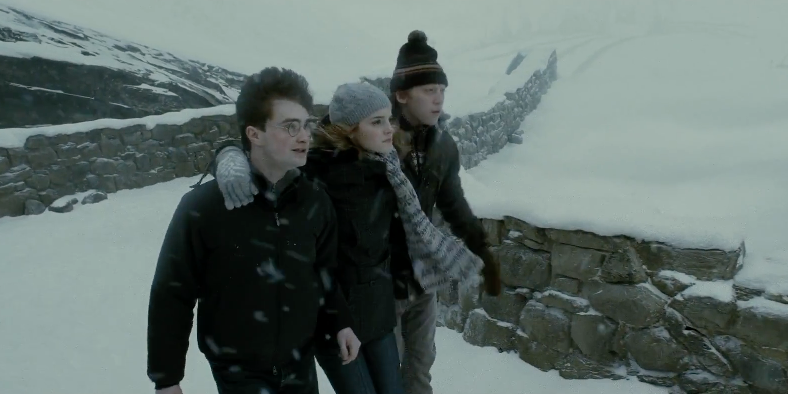 Harry, Ron and Hermione walking in the snow in the village of Hogsmeade.