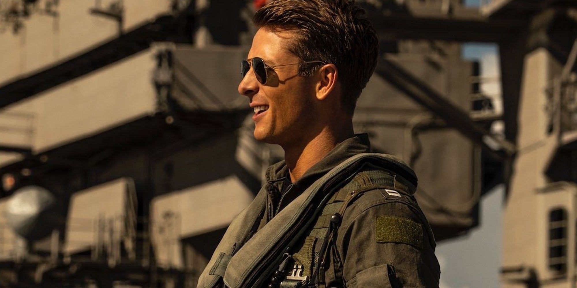 Image of Glenn Powell standing next to the helicopter in Top Gun 2