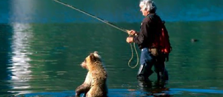 A man was fishing in the water when a cub came out of the water and asked for a fish.  It doesn't eat by itself, but gives it to the mother bear