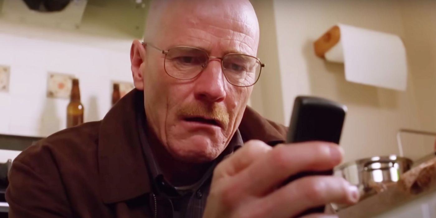 Walter White in Breaking Bad staring at his phone with disgust