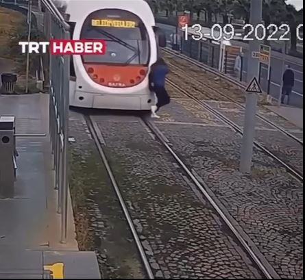 Shocking moment oblivious teen wearing headphones is knocked to ground after stepping onto track in front of tram