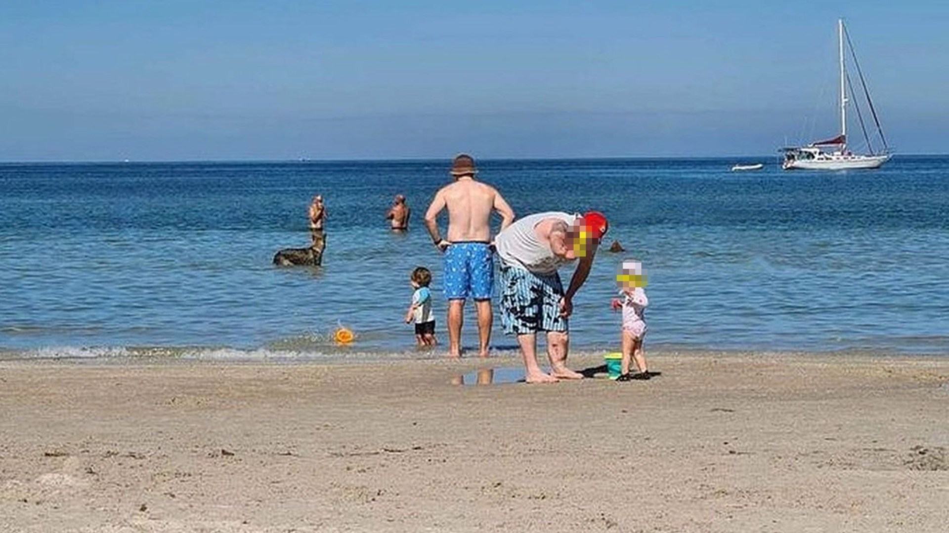 Family horrified after spotting chilling detail in the background of their beach photo... can you see it?