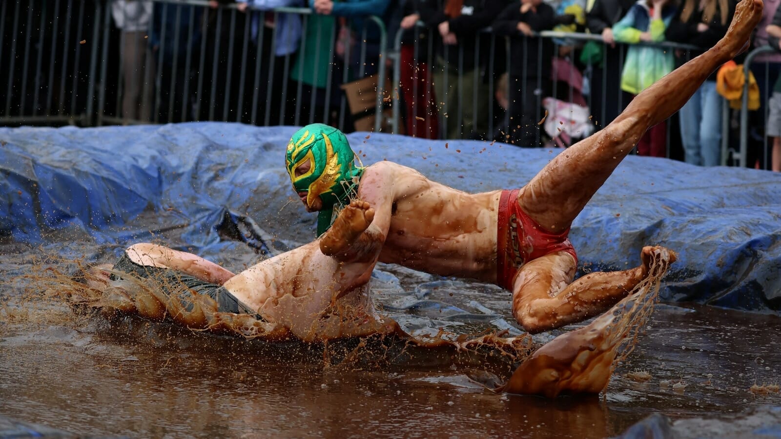 People wrestle in gravy to win the world championship title. Watch