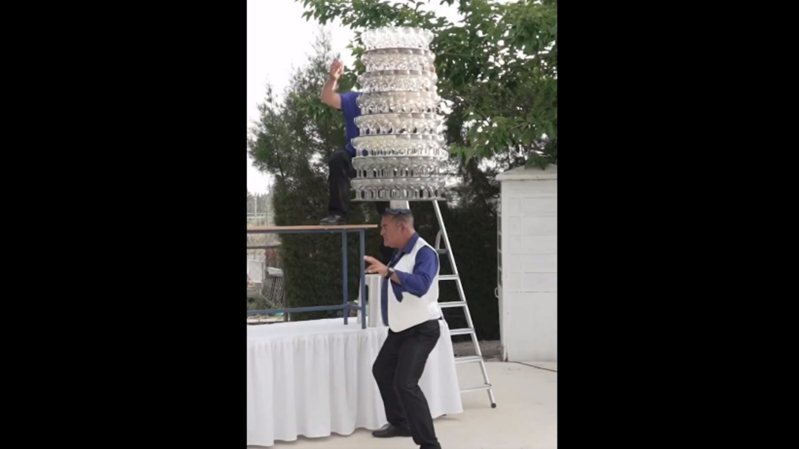 Man balances 319 glasses on his head. Watch how he smashes them at the end