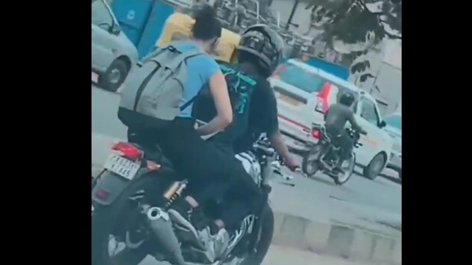 Woman works on laptop while riding pillion on bike, receives flak